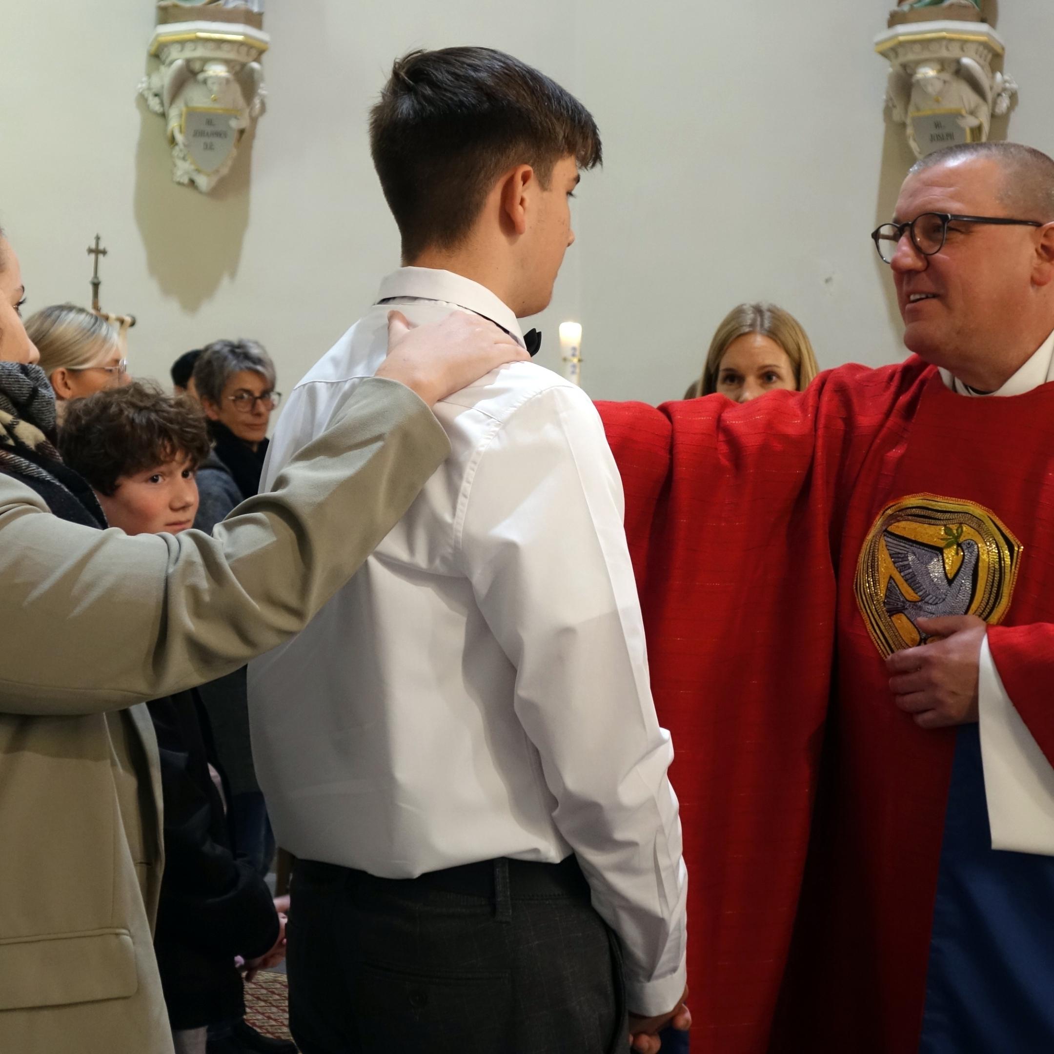 Domvikar Matthias Struth spendet einem Jugendlichen das Sakrament der Firmung (Foto: Julia Fröder/Bistum Trier)